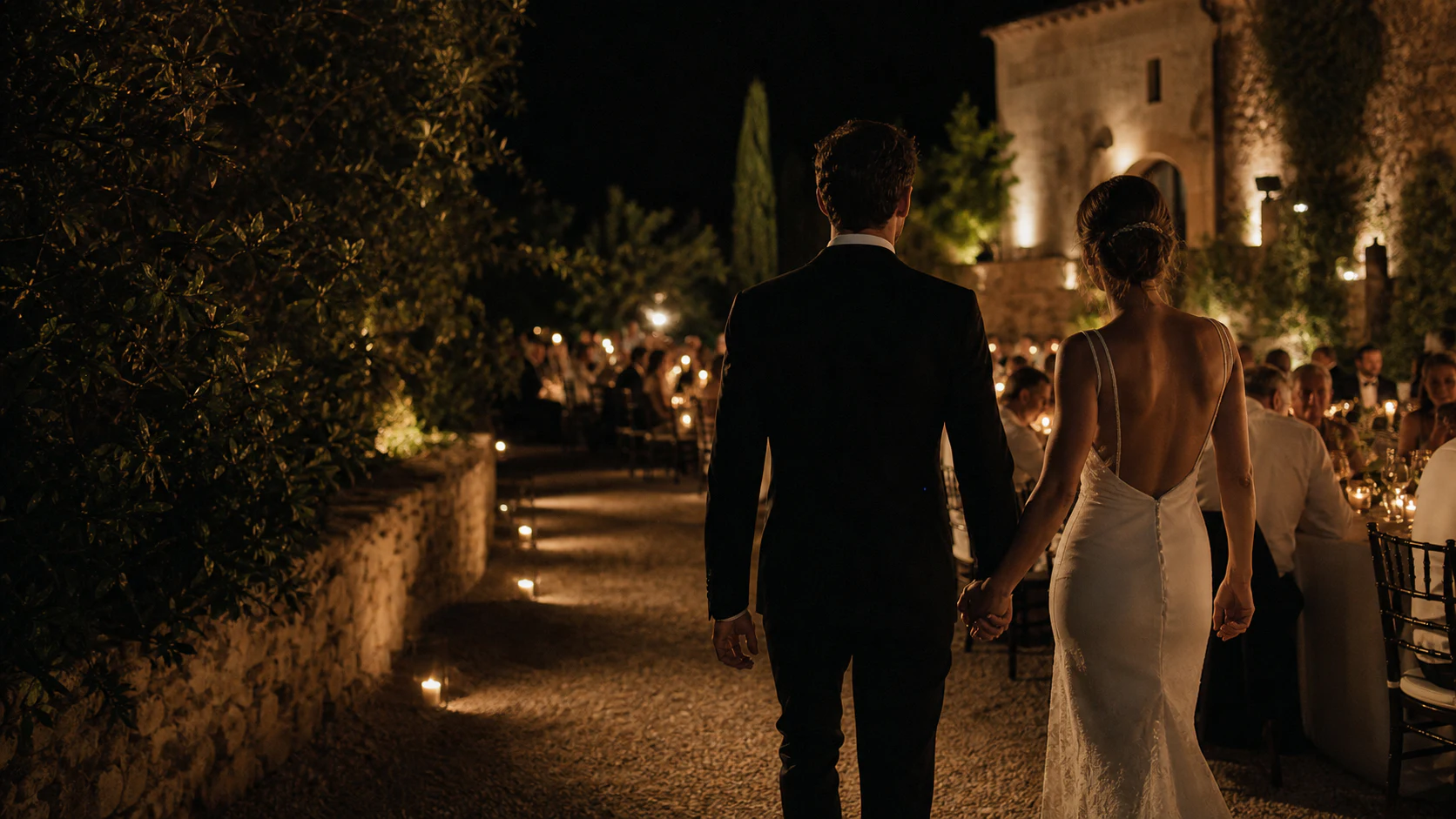A newly married couple walking into an intimate candlelit reception